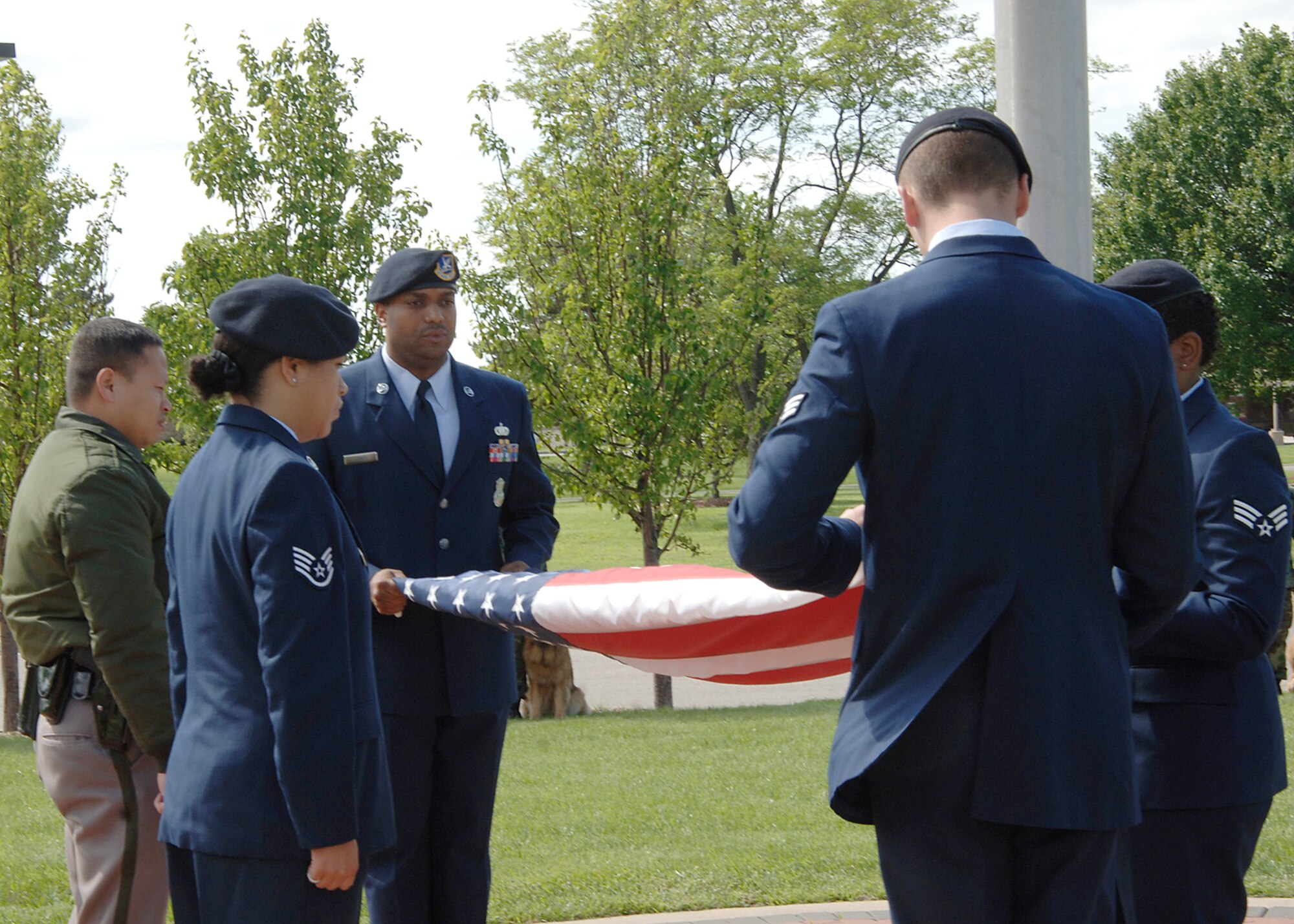 Members of the 22nd Security Forces Squadron and a Wichita police officer fold the flag during a retreat ceremony in front of Bldg. 1 May 15. The ceremony commemorates the loss of two Security Forces members and two police officers in the local community in the past year. May 15 marked the beginning of National Police Week. (Photo by Airman Justin Shelton)