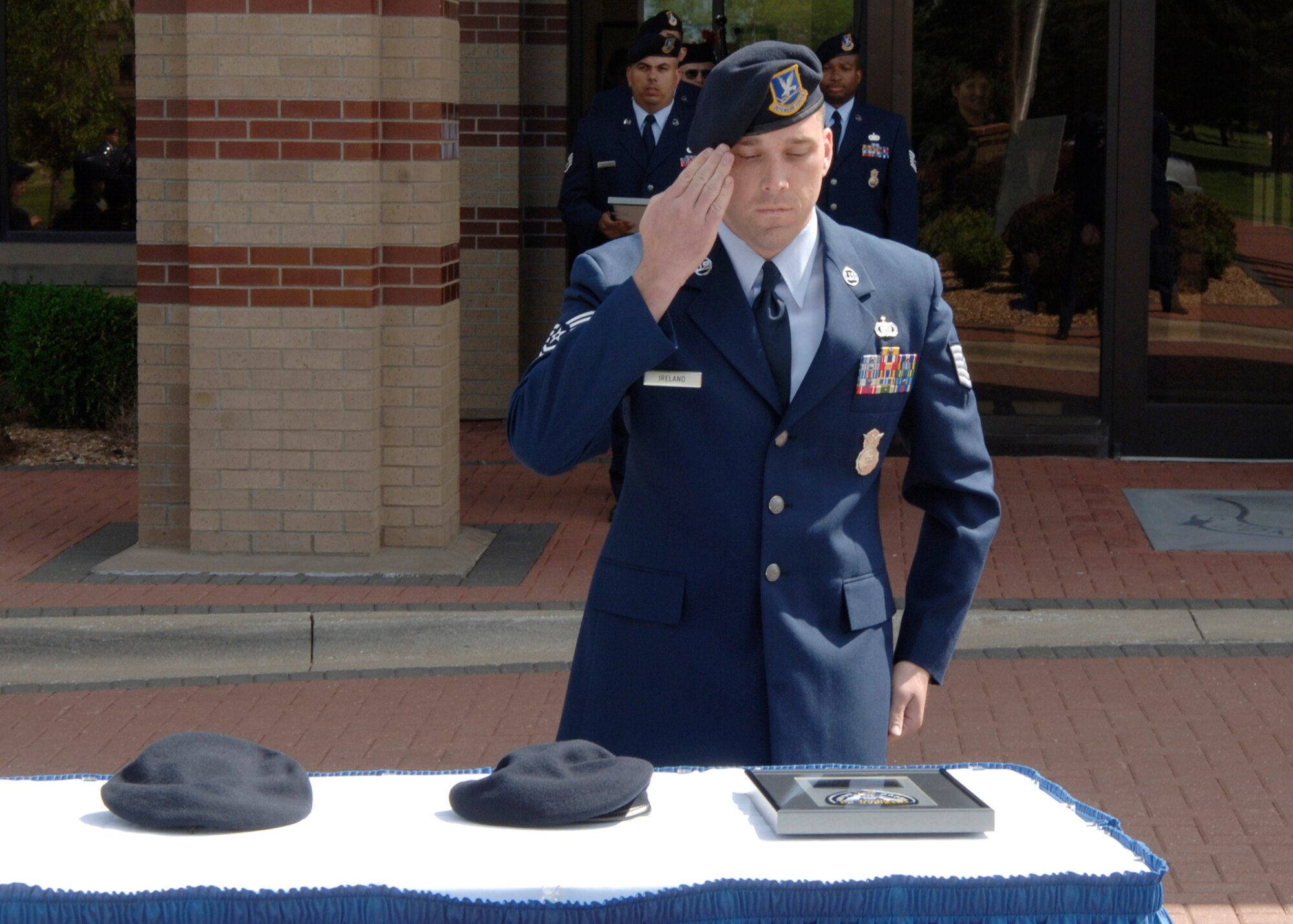 Tech. Sgt. Benjamin Ireland, 22nd Security Forces, pays respects to two fallen Air Force Security Forces members who were killed in the past year during retreat ceremony in front of Bldg. 1 May 15. This day marked the beginning of National Police Week. (Photo by Airman Justin Shelton)