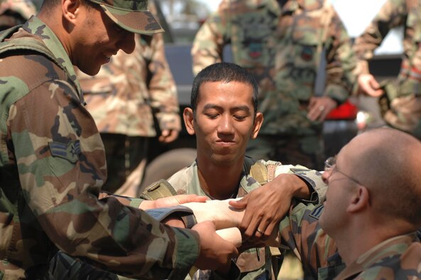 SHAW AIR FORCE BASE, S.C. -- Members of the 20th Civil Engineer Squadron splint an injury during a Self-Aid and Buddy Care demonstration while participating in a field training exercise May 22. As part of the four-day FTX the 20th CES trained in self-aid buddy care, cardiopulmonary resuscitation, weapons safety, decontamination, security, land navigation, night operations and any job-specific training required. (U.S. Air Force photo by Airman First Class Kathrine McDowell)
