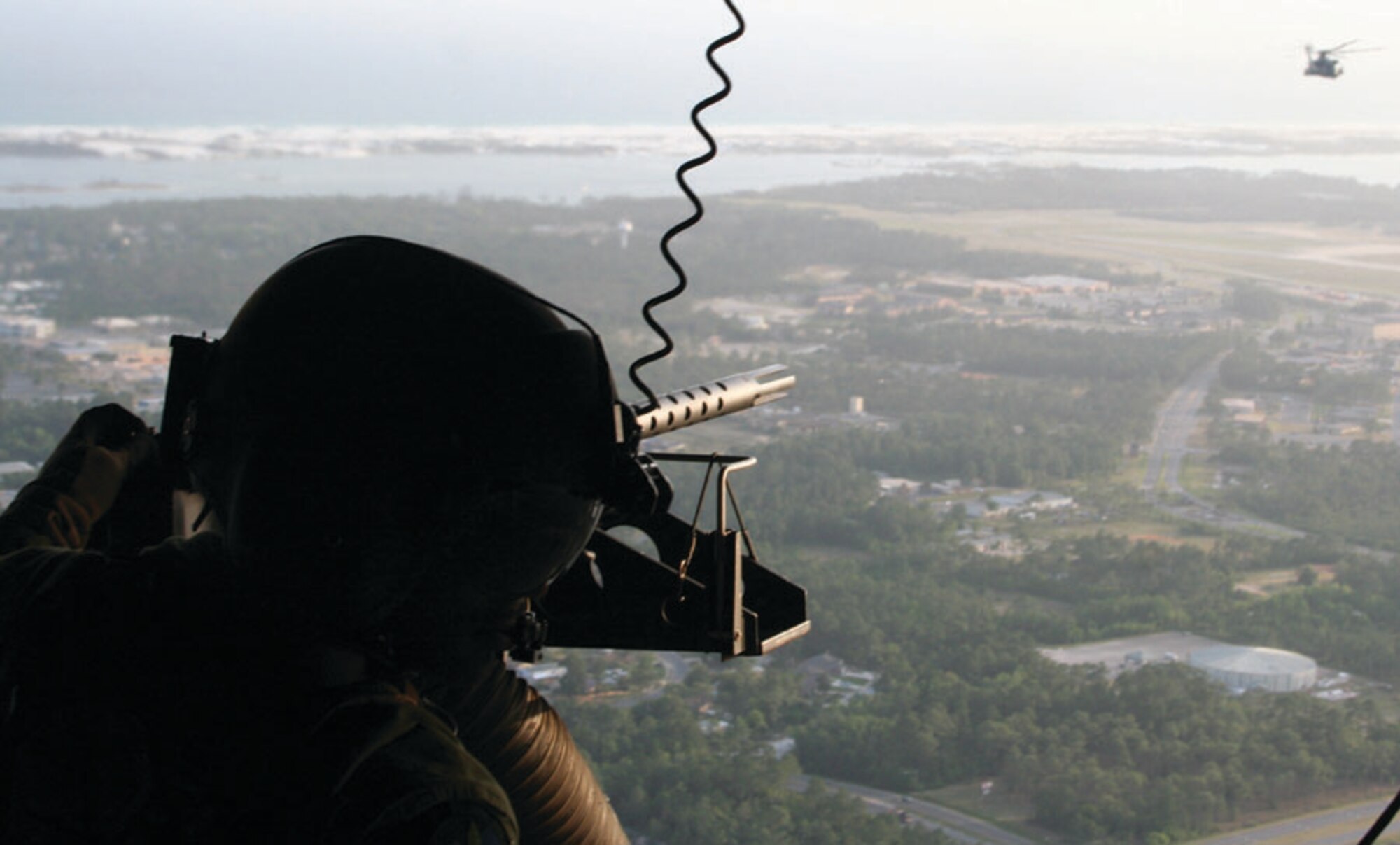 Staff Sgt. William Warrior, 20th Special Operations Squadron aerial gunner, looks out the back of an MH-53 PAVE LOW en route to Anniston, Ala., for the Special Operations Forces Exercise May 15 while another PAVE LOW follows behind. (U.S. Air Force photo by 2nd Lt. Lauren Johnson)