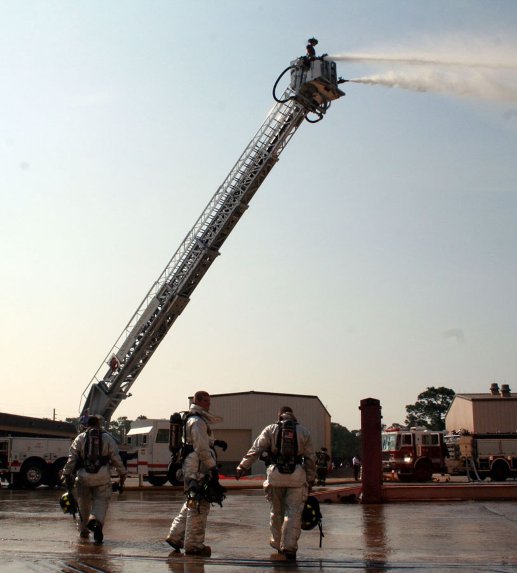 The 1st Special Operations Civil Engineer Squadron Fire and Emergency Services Flight trains with the Ocean City-Wright Fire Department Tuesday at the 823rd RED HORSE compound. The firefighters learned how to operate water canons from atop a 100-foot tower, find victims in a smoke-filled room and use electric saws to cut through metal doors. Hurlburt Field firefighters work in conjunction with the county firefighters on motor vehicle accidents, fires and emergency services. (U.S. Air Force photo by 2nd Lt. Jesse Brannen)