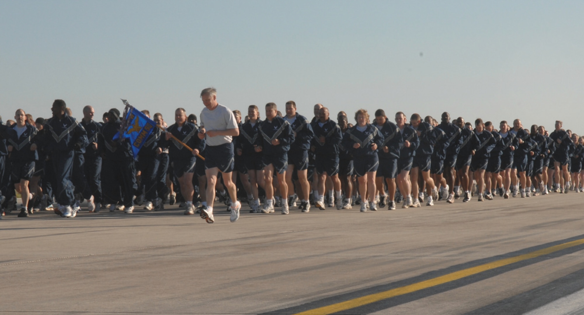 SPANGDAHLEM AIR BASE, GERMANY -- Chief Master Sgt. Vance Clarke, 52nd Fighter Wing command chief, runs alongside Airmen from the 52nd Communications Squadron during the wing fun run on the Spangdahlem Air Base flight line May 1. (US Air Force photo/Senior Airman Josie Kemp)