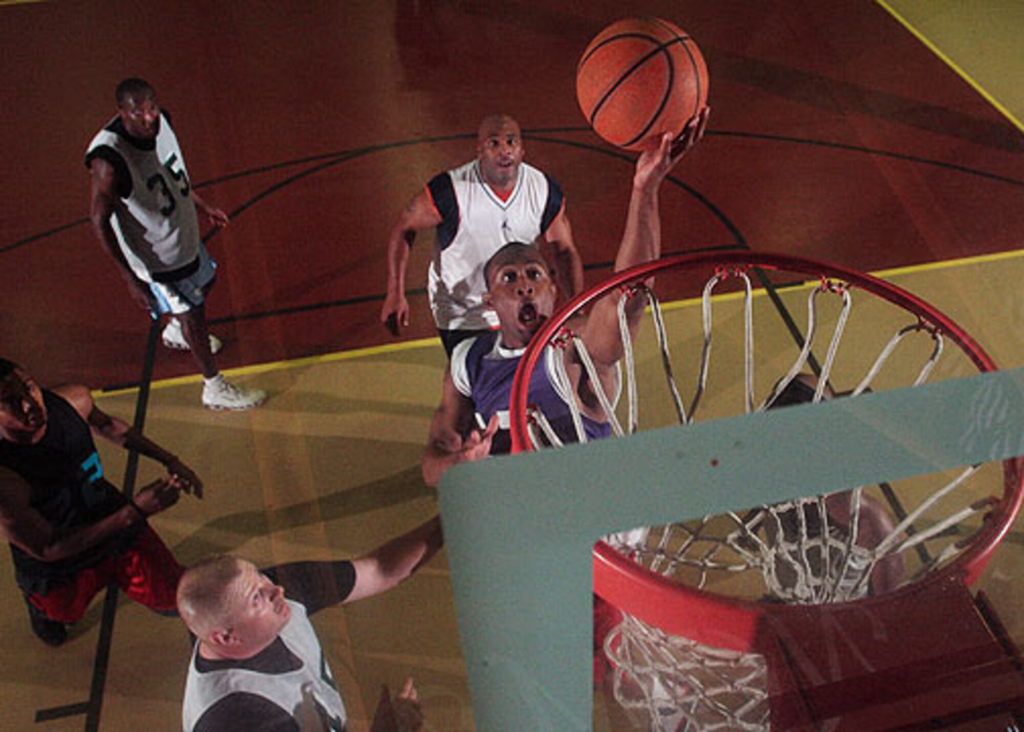 Christopher Ross, 39th Security Forces Squadron, lays a ball up over Howard Hall (45), 39th Civil Engineer Squadron during the Over-30 vs. Under-30 ARI Basketball game May 18. (photo by Ismael Gomez)
