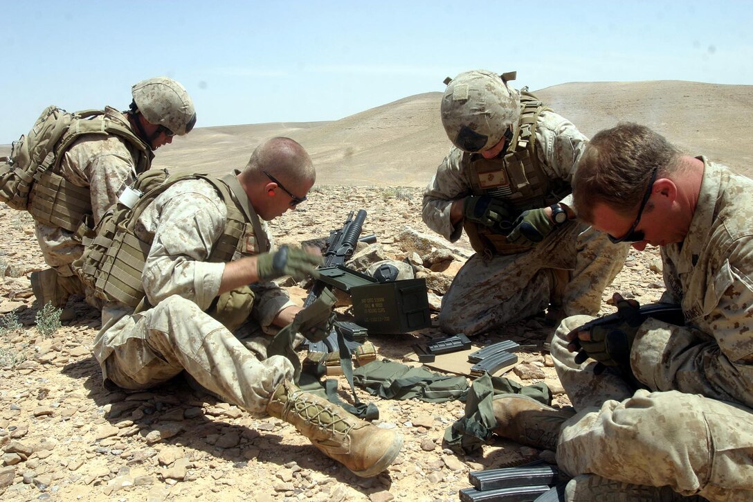 (Left to right)  Cpl. Alan R. Potts, Sgt. Jason L. Huyghe, Staff Sgt. Joshua M. Evers and Sgt. Brandon P. Gilbert, all from Reconnaissance Platoon, Battalion Landing Team 2/2, 26th Marine Expeditionary Unit, load magazines at a range in the Middle East, May 25, 2007.  The Recon Plt. was conducting live-fire ambush training alongside regional forces.  (Official USMC photo by Cpl. Jeremy Ross) (Released)