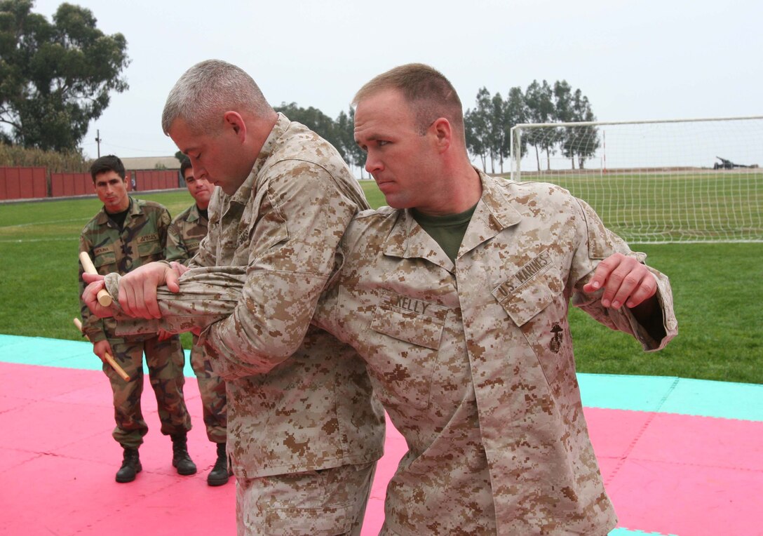 SALINAS, Chile - Demonstrating martial arts techniques to Chilean Marines are two Marine Corps Martial Arts Program Instructor-Trainers, Sgt. Shane Lavalette of Lawrence, Kan., and Sgt. Andrew Kelly of Fort Myers, Fla.  The MCMAP Marines are an augmented detachment of Special Purpose Marine Air-Ground Task Force 24, currently supporting Partnership of the Americas 2007 in Salinas, Chile.