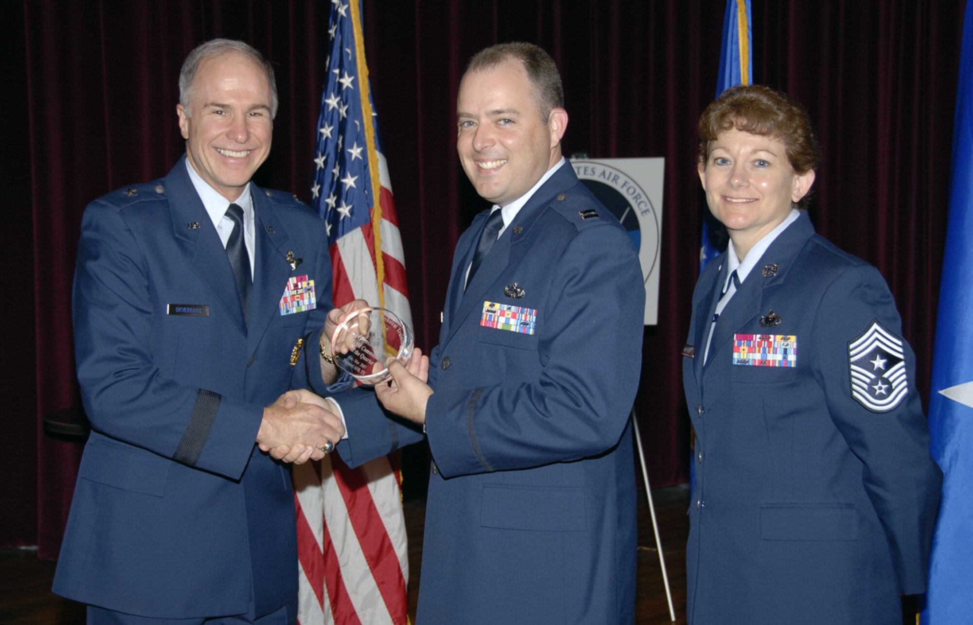 Capt. Brandon Farinelli of the 362nd Training Squadron accepts his Flight Commander of the Quarter award May 24 at the Quarterly Technical Training Award ceremony at the base theater. Captain Farinelli worked to ensure a $250,000 dorm refurbishment project was initiated and ensured dorm safety by implementing a program that involved 150 Airmen per weekend. He also served as the vice president of teh Logistics Officer Assoction Texoma Chapter. Also pictured is 82nd Training Wing Commander Brig. Gen. Richard Devereaux. (U.S. Air Force photo/Sandy Wassenmiller)