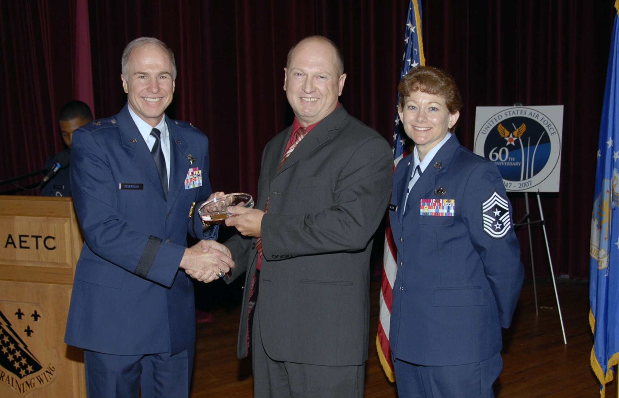 Philip Shirah, an F-16 crew chief instructor at the 362nd Training Squadron, accepts his Civilian Instructor of the Quarter at the Quarterly Technical Training Awards May 24 at the base theater. Mr. Shirah was cited for refining 166 course objectives in under three months, authored and validated F-16 landing gear interactive simulation and delivered 50 meals as part of the local Meals-on-Wheels program. Also pictured is 82nd Training Wing Commander Brig. Gen. Richard Devereaux. (U.S. Air Force photo/Sandy Wassenmiller)