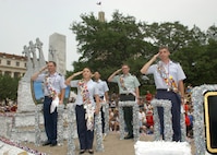 Military Ambassadors riding the joint military float in the Battle of flowers Parade salute dignitaries as they pass the Alamo Plaza reviewing stand April 27. From left are Capt. Brent Dishman, Lackland; 1st Lt. Jennifer Ferrer, Randolph; 1st Lt. Manuel Alvarez, Air Intelligence Agency, Lackland; Army Staff Sgt. Russell Burnham, Fort Sam Houston; and 1st Lt. Stephen Alexander, Brooks City-Base. Fiesta is an annual 10-day event with more than 100 scheduled events designed to honor the heroes of the Alamo
and the Battle of San Jacinto. Lackland AFB, Texas, is represented in numerous
events during the celebration, including the opening ceremonies, the Texas Cavaliers River Parade, the Battle of Flowers Parade, the Fiesta Flambeau night parade, Fiesta in Blue, the Air Force at the Alamo and the Fiesta Military Parade
on base. (USAF photo by Alan Boedeker)