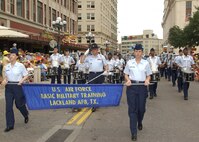 The 737th Training Group Drum & Bugle Corps, following Lackland's Band of the West in the Battle of Flowers Parade on April 27, 2007, passes the reviewing stand in Alamo Plaza. Drum Major Tech. Sgt. Ronald Gann salutes reviewing officials who included Brig. Gen. Darrell Jones, a former commander of the 37th Training Wing. Carrying the banner for U.S. Air Force Basic Military Training at Lackland AFB, Texas, are Trainees Sara Miller, left, and Alyssa Nazworth. Fiesta is an annual 10-day event with more than 100 scheduled events designed to honor the heroes of the Alamo and the Battle of San Jacinto. Lackland AFB, Texas, is represented in numerous events during the celebration, including the opening ceremonies, the Texas Cavaliers River Parade, the Battle of Flowers Parade, the Fiesta Flambeau night parade, Fiesta in Blue, the Air Force at the Alamo and the Fiesta Military Parade on base. (USAF photo by Alan Boedeker)                               