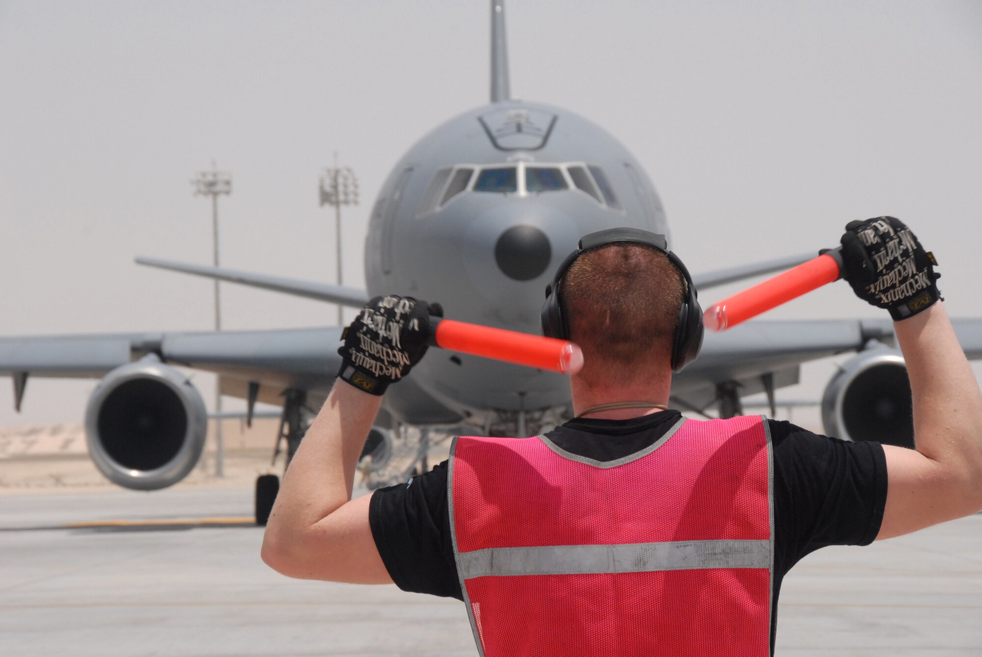 Staff Sgt. Joshua Hill marshals a KC-10 Extender at a base in Southwest Asia.  Tankers delivered 2.6 million pounds of fuel to coalition aircraft around the area of responsibility May 23.  Sergeant Hill is a crew chief with the 380th Expeditionary Aircraft Maintenance Squadron.  (U.S. Air Force photo)