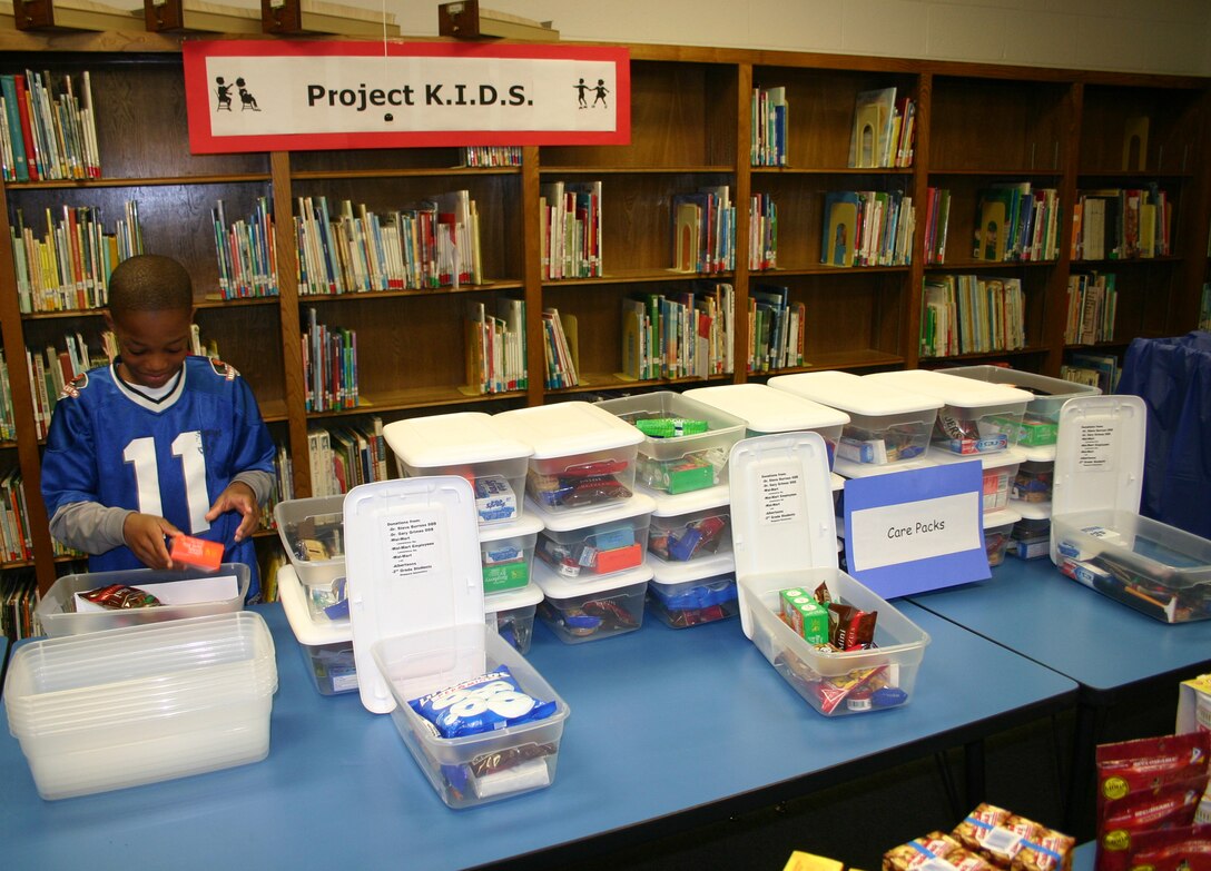 Damante Cross fills the care packages for Project K.I.D.S.  The project, initiated by the second-graders of Sheppard Elementary School, will ship the goods to both the children of Afghanistan and the servicemen deployed there. (U.S. Air Force photo/Staff Sgt. Tonnette Thompson)