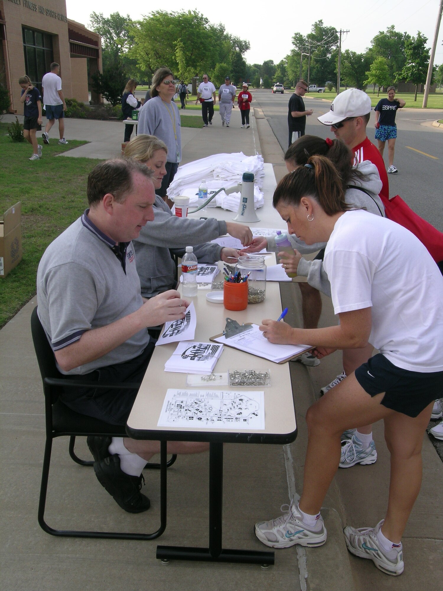 Adam Sloat, Computer Services Corporation fitness center supervisor registers Patty Tyson, CSC community services, for Saturday’s 5K run that attracted 120 runners to compete for commander’s trophy points or just enjoy an early morning run. (U.S. Air Force photo by Kate Begiebing)
