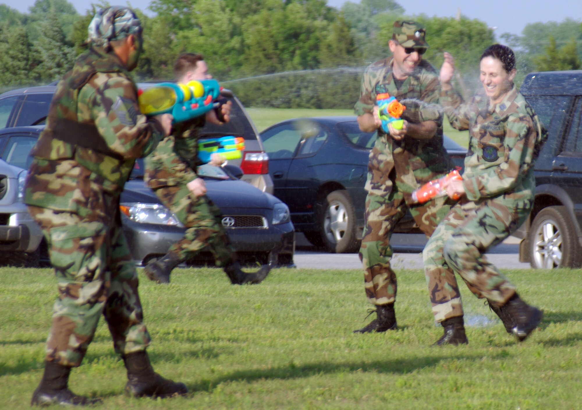 Senior Master Sgt. Todd Wheeler and Lt. Col. Lane Benefield aim their high-powered super soakers at Capt. Wendy Hymes. The three 71st Operations Support Squadron Ghostriders were among those in attendance at Saturday night’s Combat Dining Out honoring Lt. Col. Ron Baldinger, who turns over command of the squadron at Vance AFB June 14. (U.S. Air Force photo by Master Sgt. Joe Lawley)