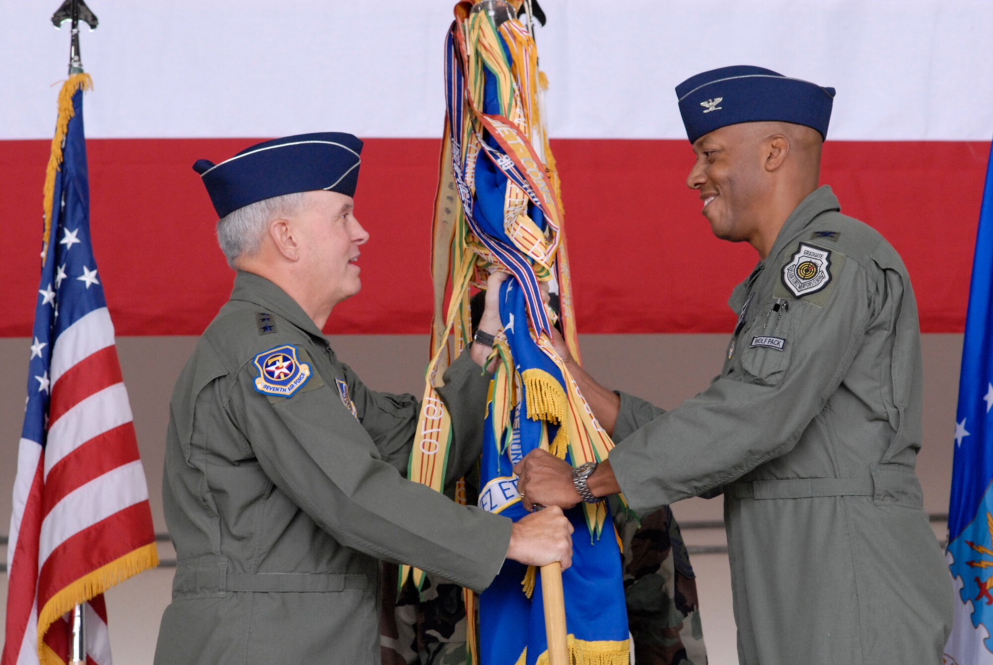 Seventh Air Force Commander Lt. Gen. Stephen Wood, hands the 8th Fighter Wing guidon to Col. Charles "Wolf" Brown, new 8th FW commander, during the change of command ceremony here May 25. General Wood said during his speech Col. Brown is an "experienced fighter pilot and leader who possesses all the tools necessary to continue the proud tradition and successes of the Wolf Pack and to lead the 8th Fighter Wing to even greater levels of excellence." (U.S. Air Force photo by Senior Airman Barry Loo)