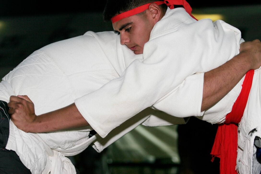 Lance Cpl. Kevin Raith competes against an Okinawa sumo wrestler during a sumo wrestling tournament in Henoko May 26. Each year, service members from Camp Schwab are invited by the Henoko community to participate in the tournament.