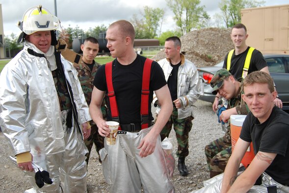 932nd Airlift Wing firefighters gather around the supply truck to drink water after being in their suits on a muggy Illinois afternoon.  Photo/ Capt. Stan Paregien