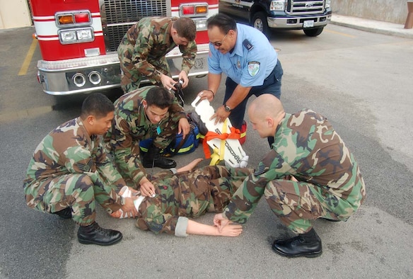 From left to right, Staff Sgt. Jason Ramirez, 36th CES/FD  Airmen 1st Class Aaron Plascencia, 36th MDG and Sean Bordonaro, 36th CES/FD, Bryan Hanohano, 36th CES/FD and Staff Sgt. Joshua Thompson, 36th CES/FD refresh on their ABC and C-Spine training. (Photo by Airman Basic Evan Carter/36th Wing Public Affairs)