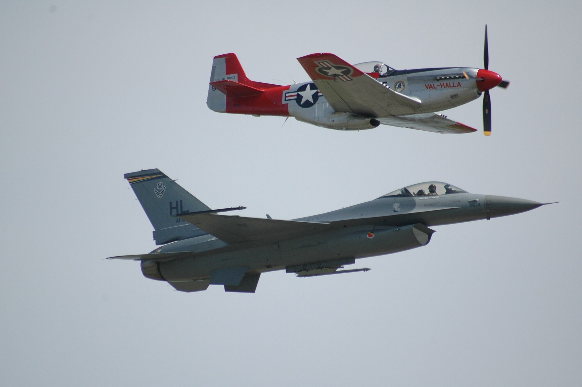 A P-51 Mustang and an F-16 Fighting Falcon fly side-by-side during and Air Combat Command-sponsored Heritage Flight over Malmstrom Air Force Base May 20. The Heritage Flight commemorates 50 years of air combat capability. (U.S. Air Force photo by Airman 1st Class Emerald Ralston)