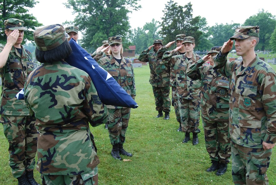 Members of the 932nd Airlift Wing salute the flag after folding it following the 2007 Belleville Memorial Day parade.