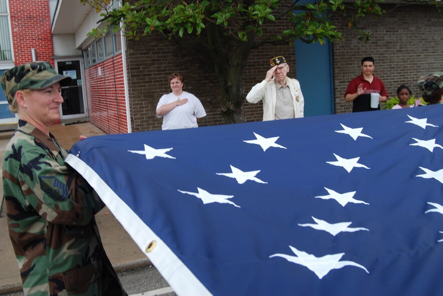 Veterans and civilians alike honor the flag as members of the 932nd Airlift Wing march past them during the 2007 Belleville Memorial Day parade.