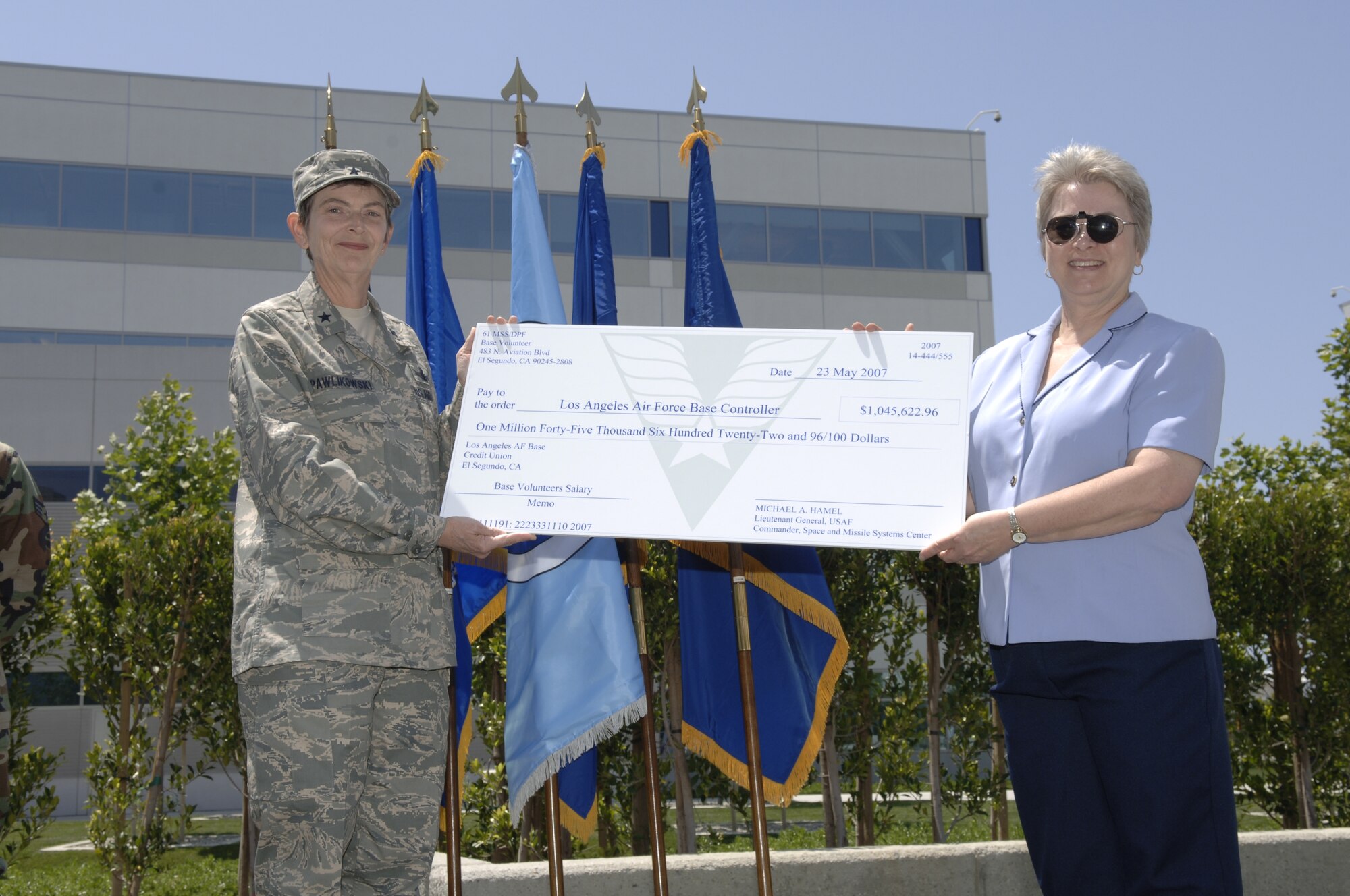 Brig. Gen. Ellen Pawlikowski accepts a check representing the money base volunteers saved by giving of their time.  Base volunteers worked 57,925 hours from April 1, 2006 through March 31 2007, saving the base $1,045,622.96 in salaries. Los Angeles Air Force Base celebrated the work of more than 290 volunteers at the annual Volunteer Recognition Ceremony and luncheonat the Schriever Space Complex, May 23. Approximately 125 volunteers and their supervisors attended the event. 