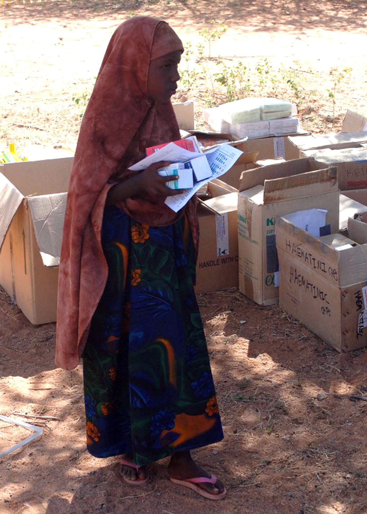 A child picks up medication during a Combined Joint Task Force - Horn of Africa Medical Civic Action Program in May in Kenya. CJTF-HOA servicemembers conducted the MEDCAP in the villages of Shimbir and Balich through a partnership with the Kenyan department of defense, which provided additional medical providers and logistical support. More than 1,000 people received healthcare as part of the project. (U.S. Air Force photo/Tech. Sgt. Carrie Bernard) 
