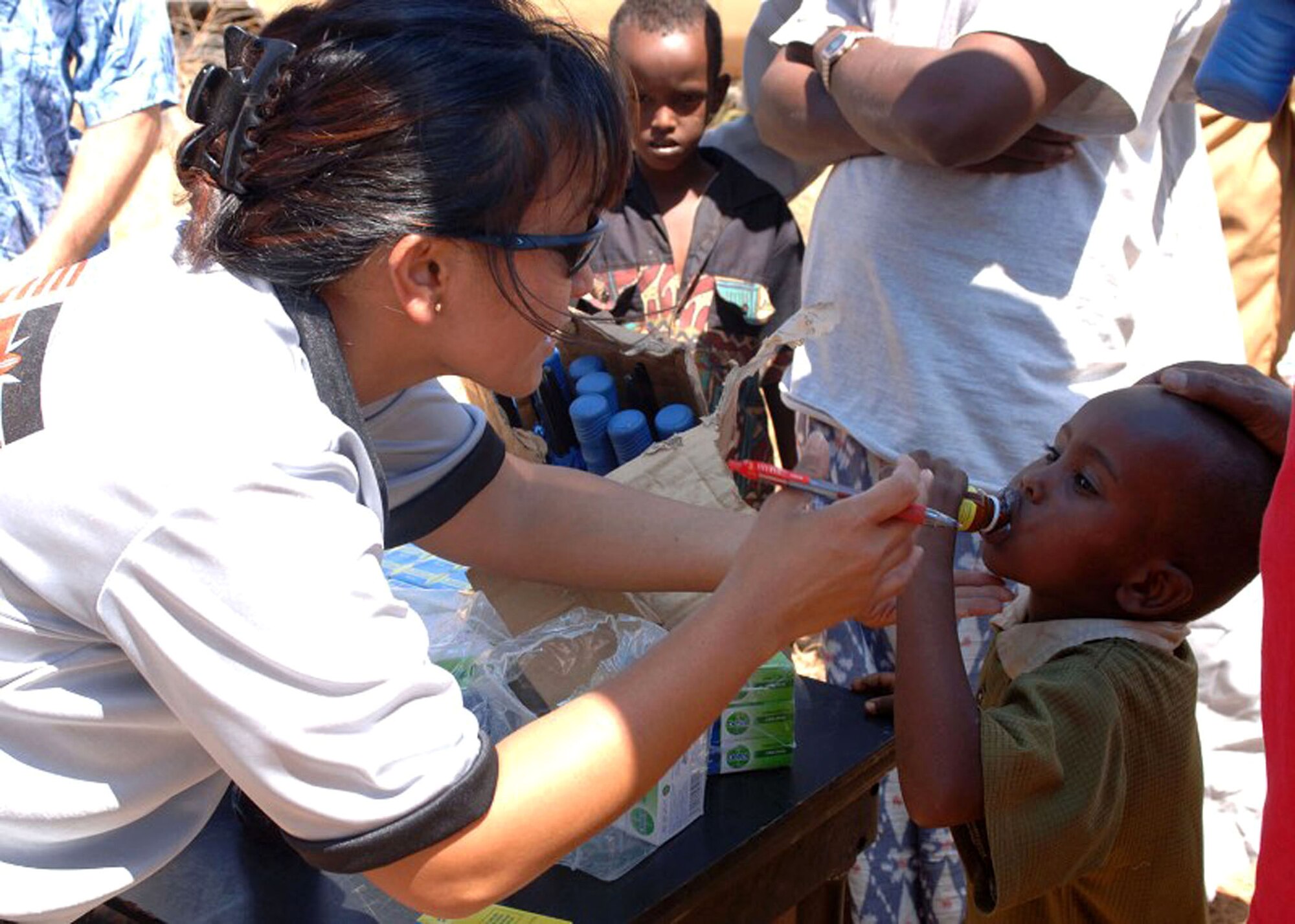 Maj. Pauline Lucas gives a child de-wormer medication during a Combined Joint Task Force - Horn of Africa Medical Civic Action Program in May in Kenya. CJTF-HOA servicemembers conducted the MEDCAP in the villages of Shimbir and Balich through a partnership with the Kenyan department of defense, which provided additional medical providers and logistical support. More than 1,000 people received healthcare as part of the project. Major Lucas is a CJTF-HOA public health officer. (U.S. Air Force photo/Tech. Sgt. Carrie Bernard) 
