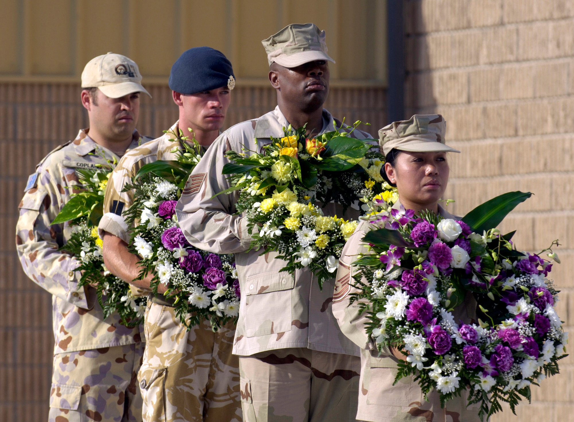 Master Sgt. Juliet Alonso and a multinational wreath bearing team prepare to lay wreaths as coalition partners from several countries gathered May 28 at this deployed location in Southwest Asia to participate in a Memorial Day ceremony. Sergeant Alonso is a services specialist deployed from Dobbins Air Reserve Base, Ga., and hails from Centerville, Ga. Originally known as Decoration Day, Memorial Day ceremonies are a time to pay tribute to servicemembers who have paid the ultimate sacrifice in securing freedom. (U.S. Air Force photo/Master Sgt. Jim Varhegyi) 
