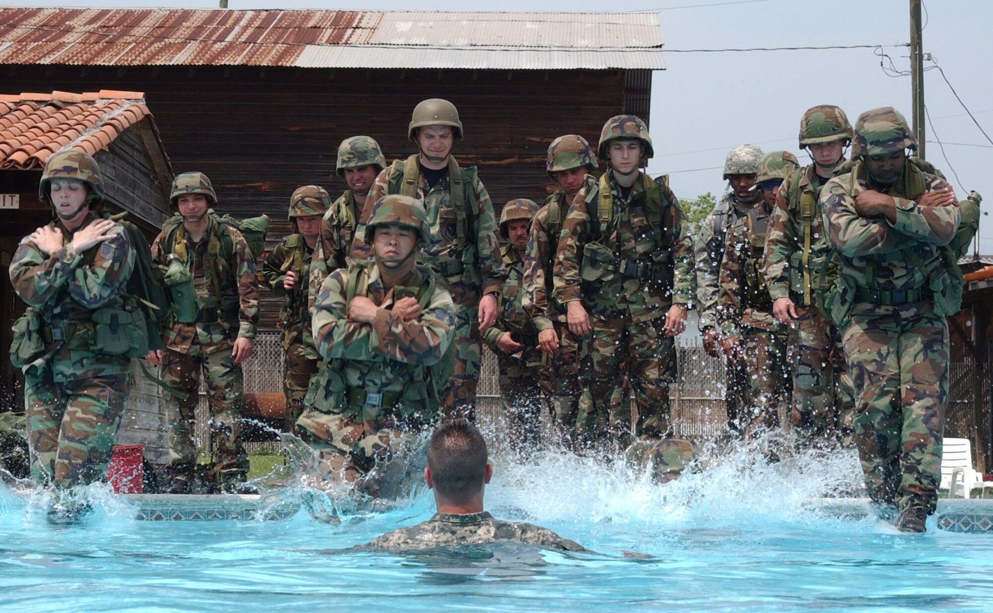 From left, Tech. Sgt. Ashley Williams, Senior Airman Jonathan Rivera and Senior Airman Michael Martin, Soto Cano Air Base Search and Rescue team members step off into the base pool as Sgt. Mark Springer, SAR instructor looks on, during combat water survival/drownproffing training May 23, 2007. U.S. Air Force photo by Senior Airman Shaun Emery. 