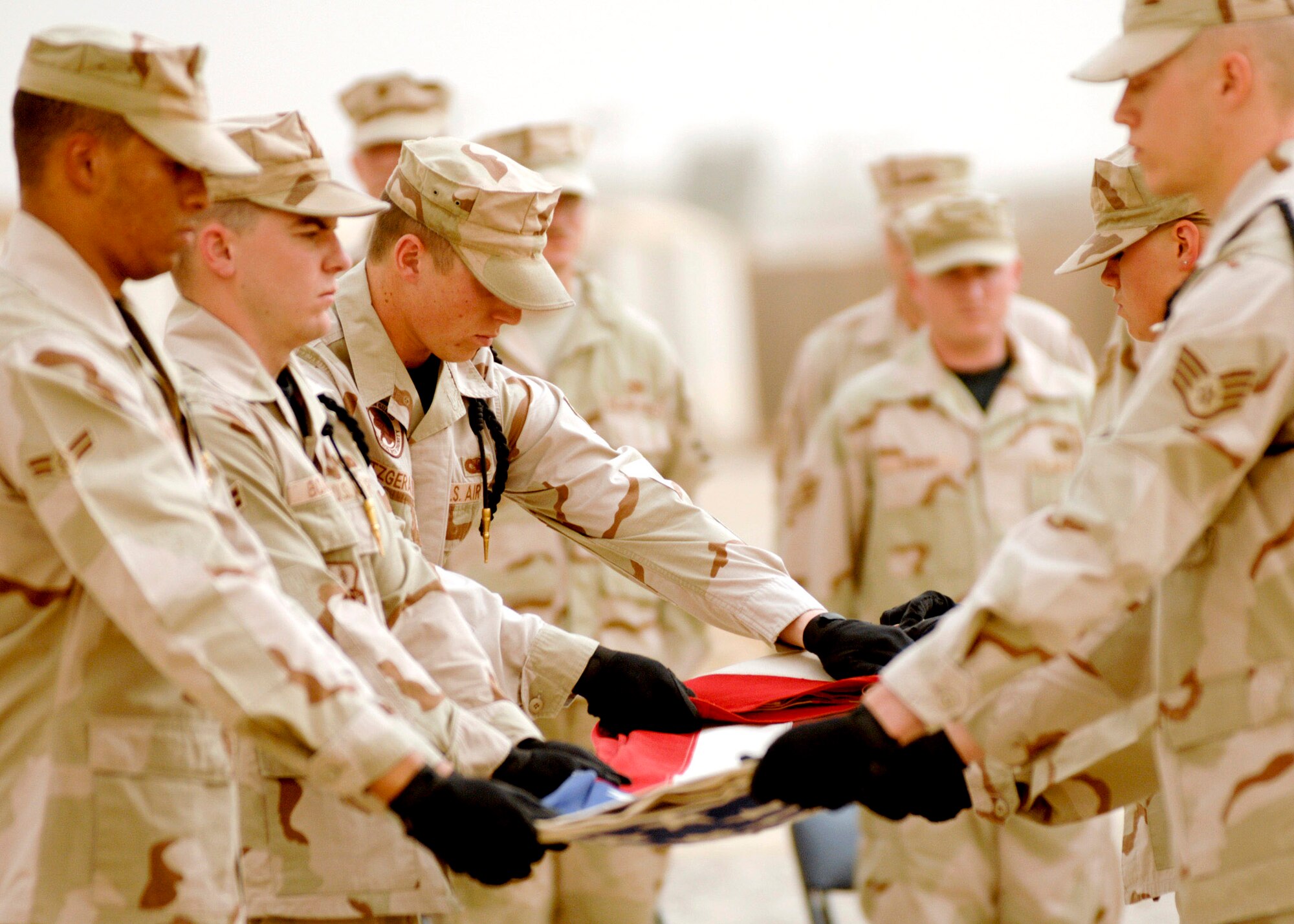 Honor Guard members from the 407th Expeditionary Group perform a flag folding ceremony during a fallen Airmen ceremony May 28 in remembrance of Staff Sgt John Self at Ali Air Base, Iraq. Sergeant Self, a security forces member assigned to the 732nd Expeditionary Security Forces Squadron at Camp Bucca, Iraq, was killed May 14 by an improvised explosive device while on patrol. (U.S. Air Force photo/Master Sgt. Robert W. Valenca)