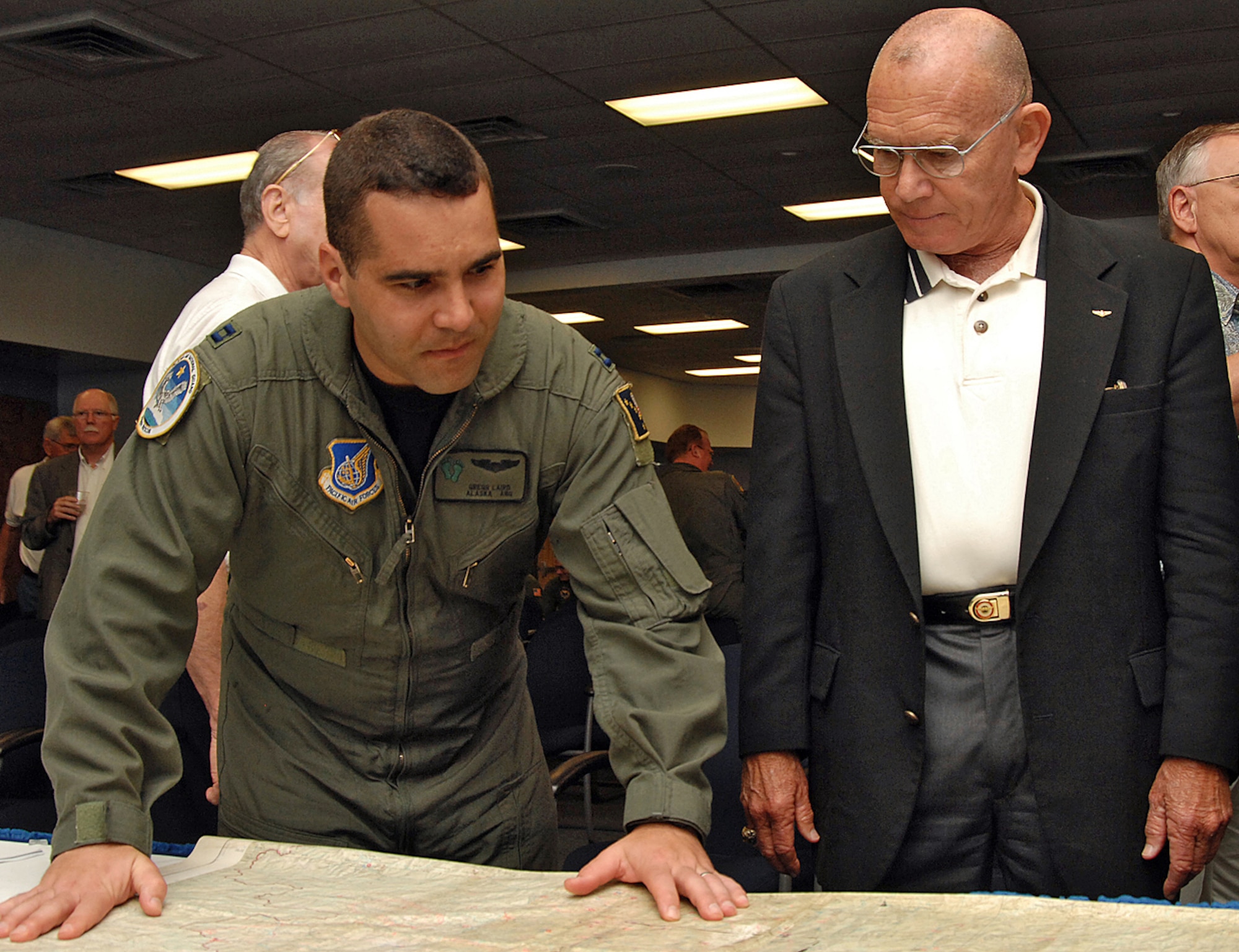 Capt. Greg Laird, a 210th Rescue Squadron pilot, Eielson AFB, Alaska, looks over a map of Laos with retired Marine Maj. Gen. Larry Taylor at the Society of Combat Search and Rescue?s 10th annual reunion here May 18. The Society of CSAR is a group of servicemembers with combat search and rescue experience that assemble to share their experiences with the public and current combat search and rescue servicemembers. U.S. Air Force photo by Todd Berenger