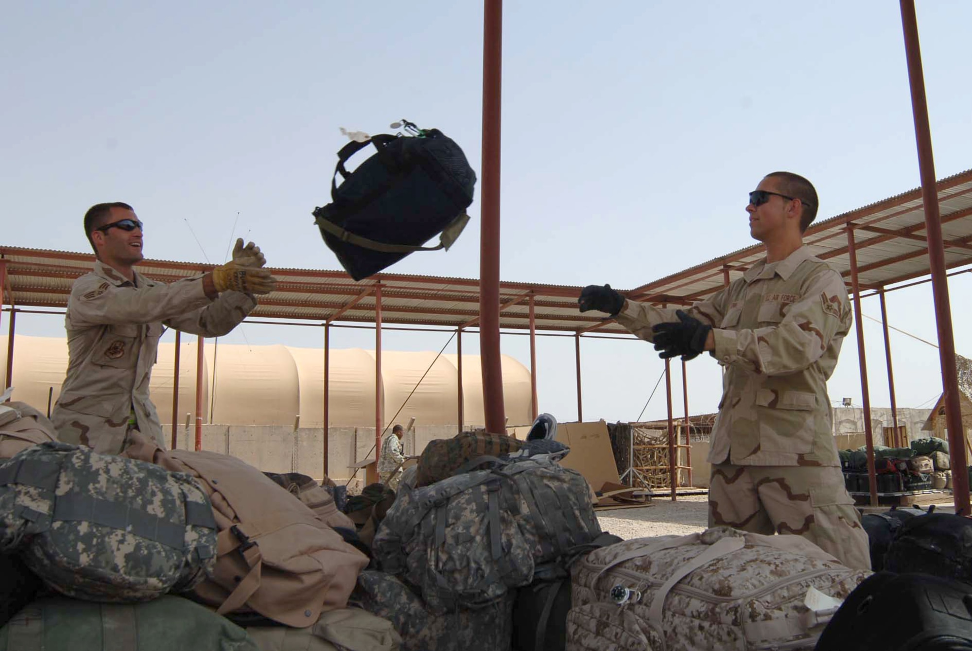 Senior Airman Jonathon Burns (left) and Airman 1st Class Michael Senn, 447th Logistics Readiness Squadron air transportation specialists, build a passenger baggage pallet at the aerial port at Sather Air Base, Iraq, for outgoing troops. Their flight works around the clock to process more than 5,000 passengers and their baggage weekly. (U.S. Air Force photo/Tech. Sgt. Russell Wicke)