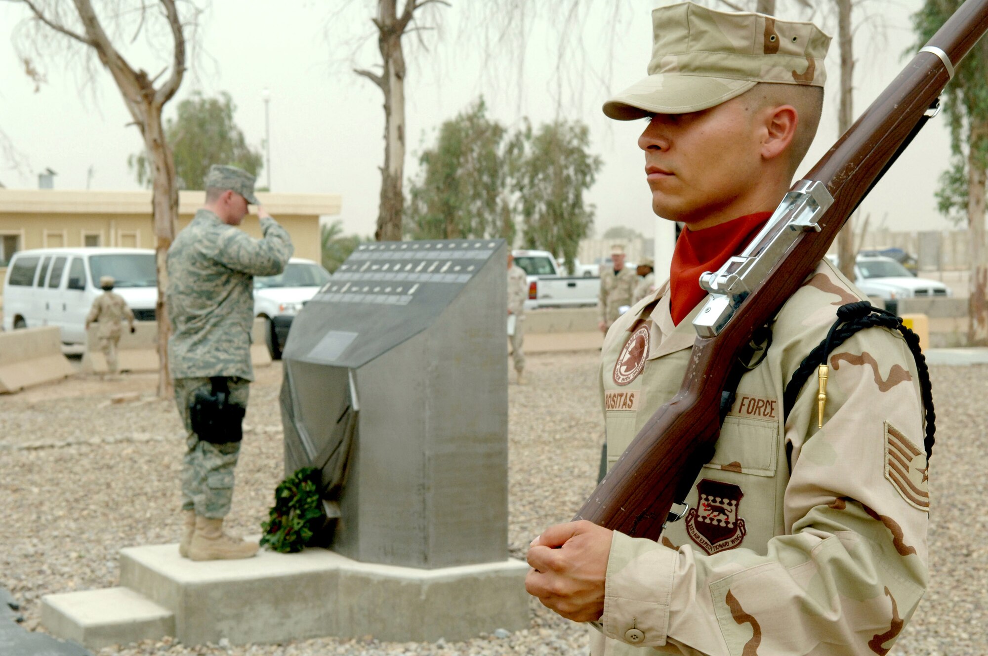 Honor guard member Tech. Sgt. Richard Rositas watches over the Fallen Airman Memorial at Balad Air Base, Iraq, May 28 as an Airman in the background pays tribute to the fallen. More than 300 Airmen gathered to pay tribute to servicemembers who made the ultimate sacrifice defending freedom. (U.S. Air Force photo/Airman 1st Class Jonathan Steffen)