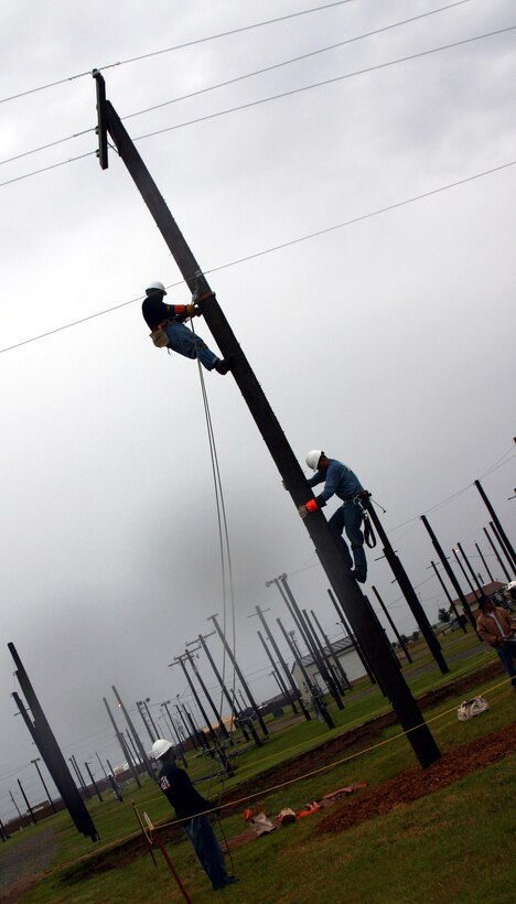 Senior Airman Kevin Flamer, Staff Sgt. Thomas Prado and Staff Sgt. Kolan Campbell compete in the insulator replacement challenge during the Linemen's Rodeo May 19. They are members of the 316th Civil Engineer Squadron, Andrews AFB, Md. (U.S. Air Force photo/Staff Sgt. Tonnette Thompson)