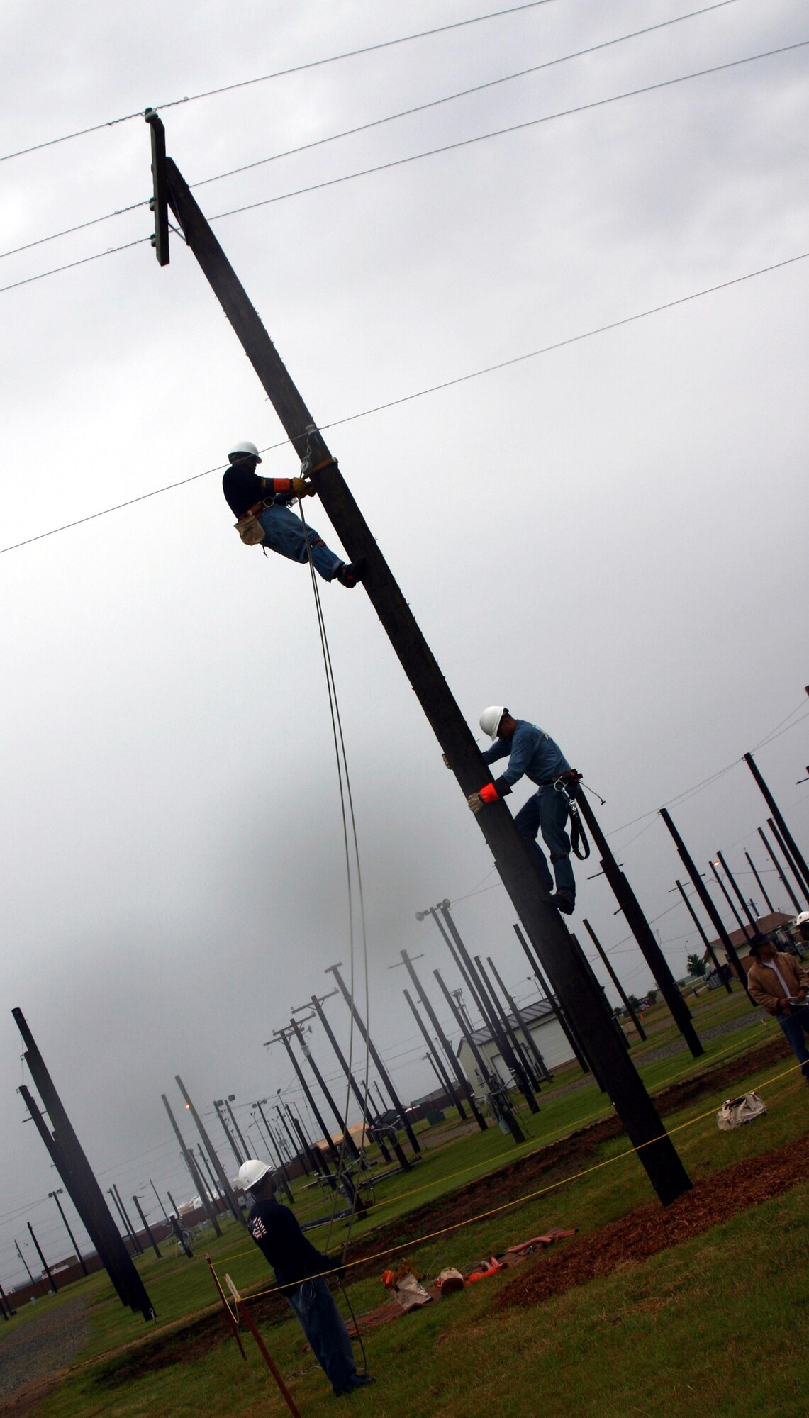 Senior Airman Kevin Flamer, Staff Sgt. Thomas Prado and Staff Sgt. Kolan Campbell compete in the insulator replacement challenge during the Linemen's Rodeo May 19. They are members of the 316th Civil Engineer Squadron, Andrews AFB, Md. (U.S. Air Force photo/Staff Sgt. Tonnette Thompson)
