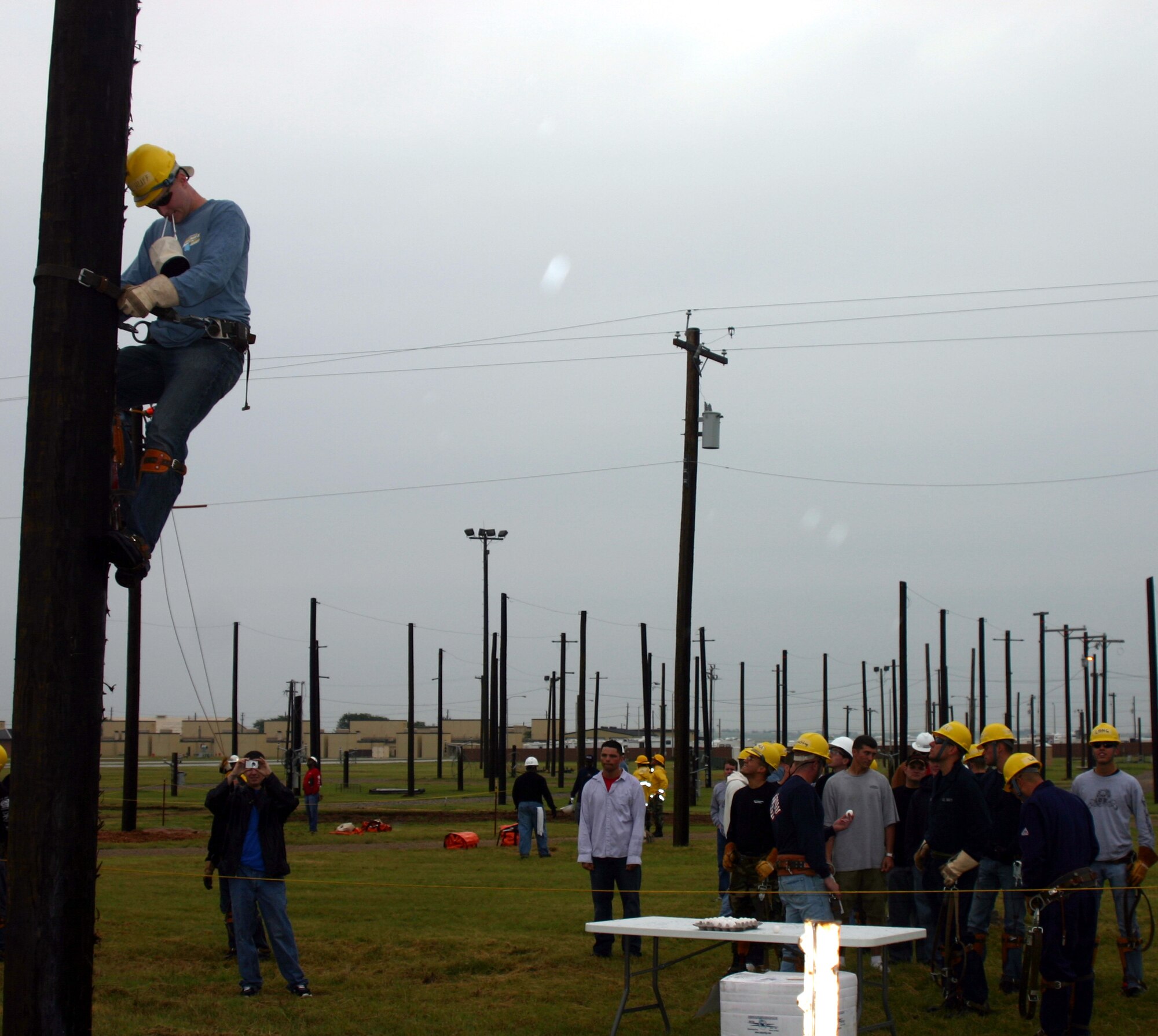 Spectators and contestants look on as Airman Steven Huff, 366th Training Squadron, competes in the egg climb challenge at the Linemen's Rodeo May 19. (U.S. Air Force photo/Staff Sgt. Tonnette Thompson)