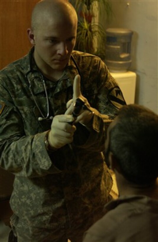 U.S. Army Pvt. John Allen checks an Iraqi man's vision after he was freed from a suspected al Qaeda prison camp south of Baqubah, Iraq, on May 27, 2007.  U.S. soldiers liberated 41 men from the camp.  Allen is from the 215th Brigade Support Battalion, 3rd Brigade Combat Team, 1st Cavalry Division.  