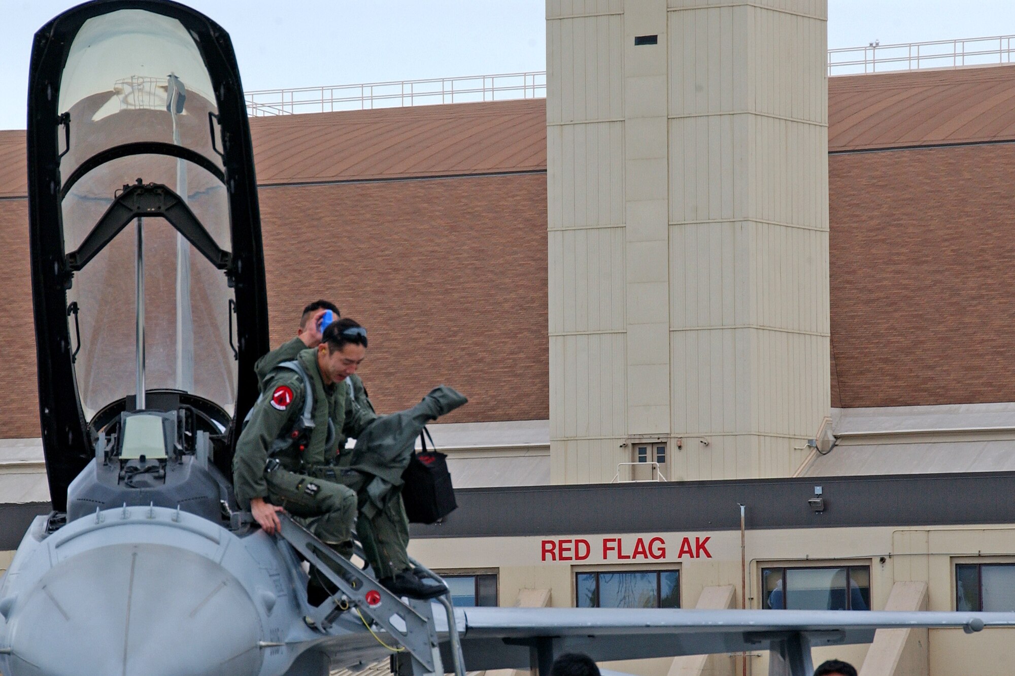 EIELSON AIR FORCE BASE, Alaska--Republic of Singapore air force pilots, from the 425th Fighter Squadron, climb out of their F-16 on the Eielson runway May 30. More than 1,400 military members from the United States, Singapore and Australia are participating in Red Flag-Alaska 07-2 scheduled from May 31 to June 15. Red Flag-Alaska, a series of Pacific Air Forces commander-directed field training exercises for U.S. forces, provides joint offensive counter-air, interdiction, close air support, and large force employment training in a simulated combat environment.(U.S. Air Force photo by Senior Airman Justin Weaver). 