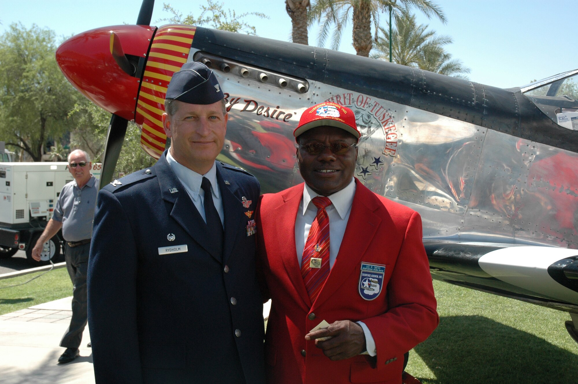 Col. Derek Rydholm, 944th Fighter Wing commander, poses for a photo with Lee Owens in front of the "Spirit of the Tuskegee Airmen" replica P-51D Mustang parked on the Arizona capitol lawn May 24, 2007, in recognition of the Congressional Gold Medal Award Ceremony honoring Arizona's Tuskegee Airmen. Colonel Rydholm has commanded two of the original Tuskegee Airmen squadrons, the 301st and 302nd Fighter Squadron, at Luke Air Force Base. Mr. Owens, chief pilot for Glendale Aviation, hopes to make a round-the-world flight to honor the Tuskegee Airmen. (U.S. Air Force photo/Tech. Sgt. Susan Stout)