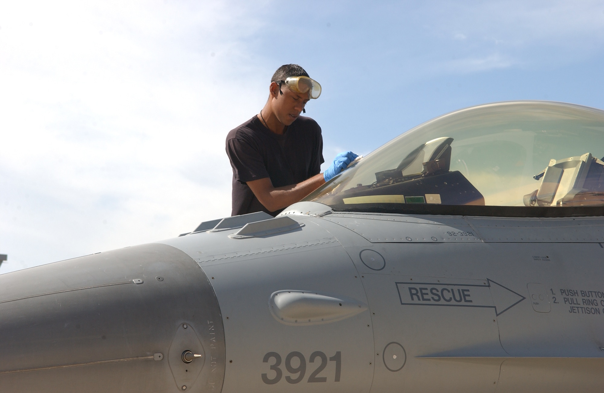 CANNON AIR FORCE BASE, N.M. -- Airman 1st Class Roman Thomas, 524th Aircraft Maintenance Unit, cleans the outer cockpit of an F-16 from the 522nd Fighter Squadron on May 27. Nearly 400 Cannon Airmen and 18 F-16s deployed to Anderson Air Force Base, Guam to suport security  responsibilities throughout the Asia-Pacificregion, (U.S. Air Force photo by Tech. Sgt. Scott Mackay)