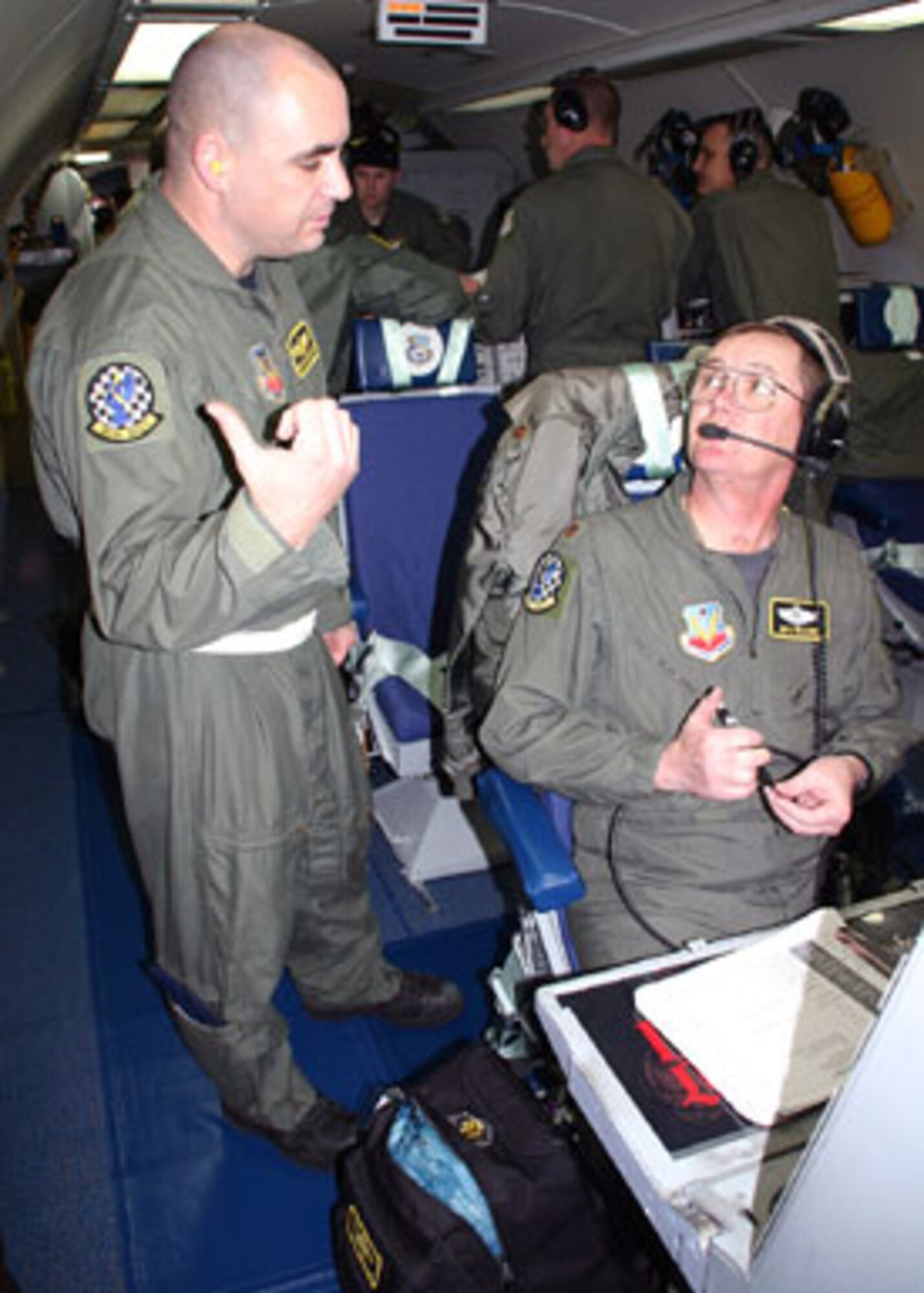 Maj. Jonathan Williams, 963rd Airborne Air Control Squadron mission crew commander, discusses pre-flight issues with Tech. Sgt. Thomas Cotton, also with the 963rd 