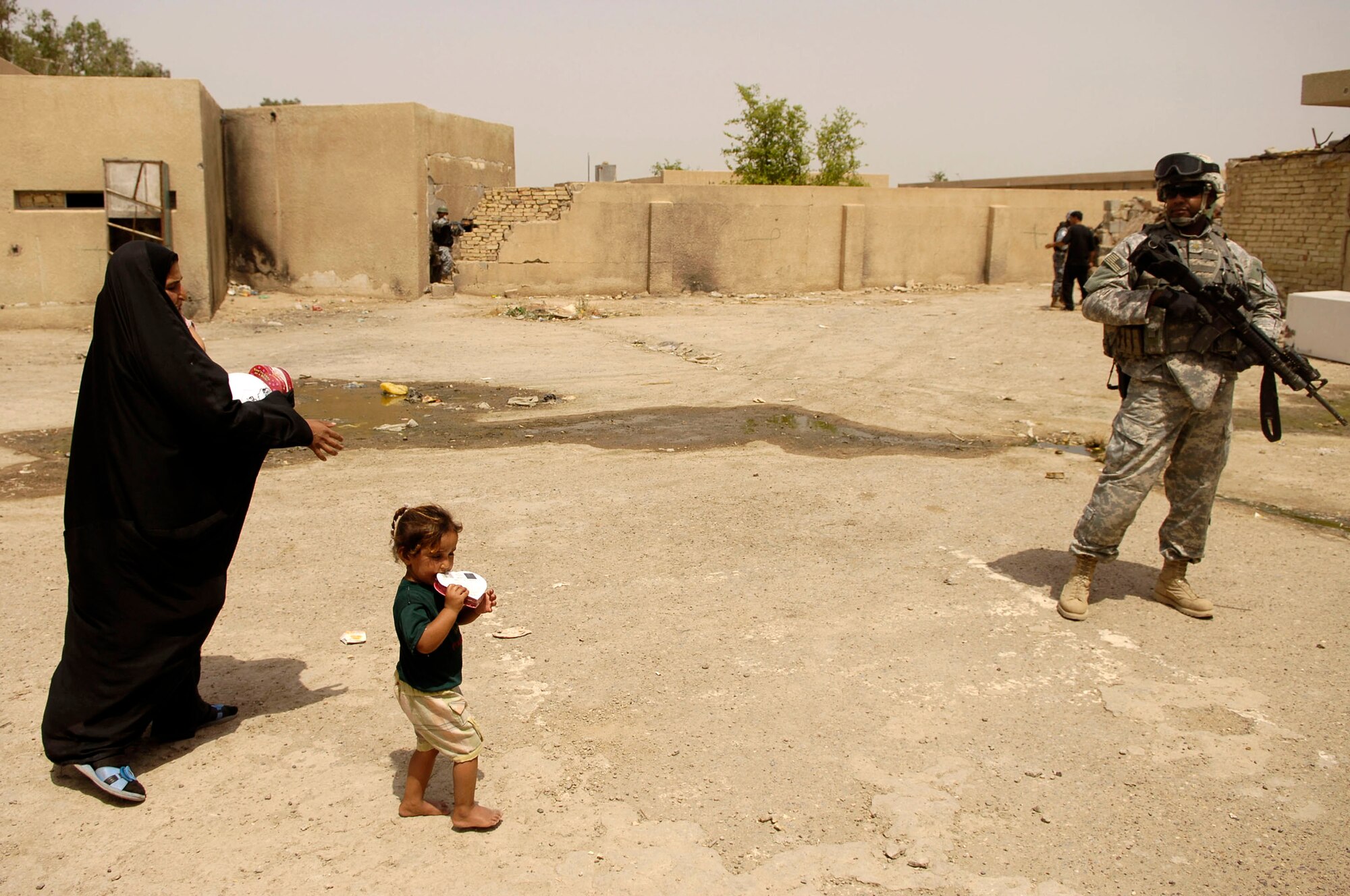 An Iraqi mother and child walk together after receiving chocolate May 24 from the Iraqi National Police in Al Furat, Iraq. During a recent humanitarian mission, U.S. servicemembers worked with the Iraqi police to distribute school supplies and toys to Iraqi children. (U.S. Air Force photo/Master Sgt. Brian L. Boone)