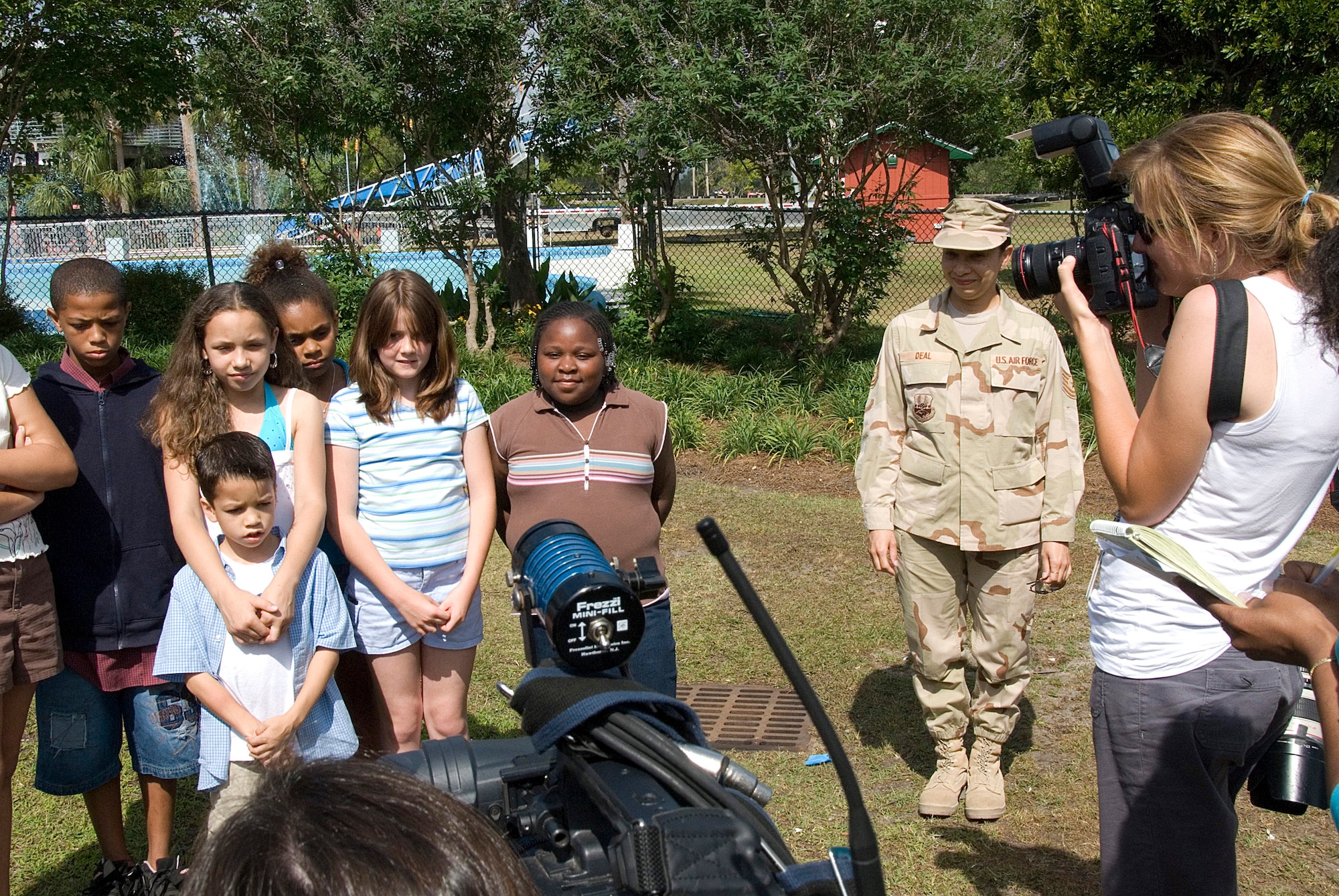 Tech. Sgt. Caroline Deal, 437th Airlift Wing paralegal, approaches children at her daughter's birthday party who were being filmed by local media to send a message to Sergeant Deal May 26. Sergeant Deal had returned home from a deployment to Iraq the day before but had kept it a secret so she could surprise her children. (U.S. Air Force photo/Senior Airman Sam Hymas)