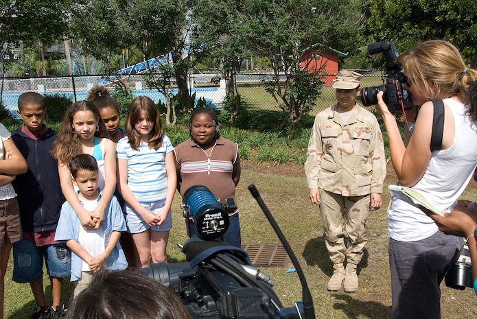 Tech. Sgt. Caroline Deal, 437th Airlift Wing paralegal, approaches children at her daughter's birthday party who were being filmed by local media to send a message to Sergeant Deal May 26. Sergeant Deal had returned home from a deployment to Iraq the day before but had kept it a secret so she could surprise her children. (U.S. Air Force photo/Senior Airman Sam Hymas)