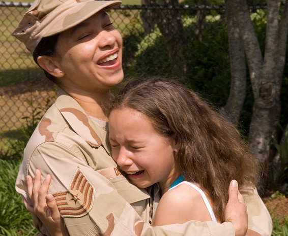 Tech. Sgt. Caroline Deal, 437th Airlift Wing paralegal, gets a tearful hug from her daughter, Taylor Deal, after surprising her at her birthday party May 26. Sergeant Deal returned home from a deployment to Iraq the day before but had kept it a secret so she could surprise her children. (U.S. Air Force photo/Senior Airman Sam Hymas)