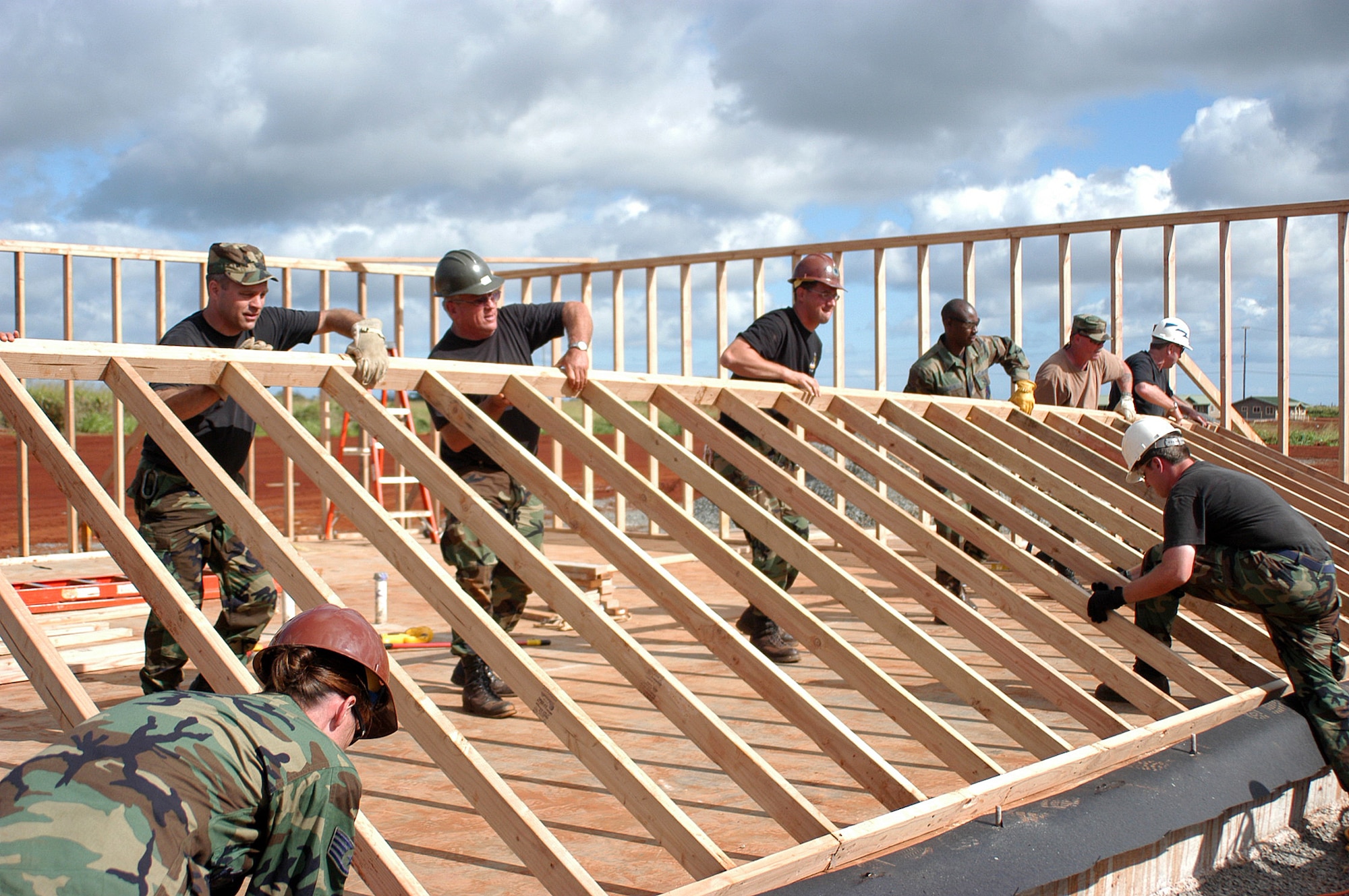 301st Civil Engineer Squadron members help raise the framework on one of the three houses built during their two-week deployment to Oahu, Hawaii. The twenty-person Air Force Reserve team also helped construct an office warehouse and other various projects which will support and house elderly and disabled community members. (U.S. Air Force Photo/Tech. Sgt. Stephen Bailey) 