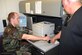 Staff Sgt. Robert Payne, 437th Mission Support Squadron customer service technician, helps scan the fingerprint of Richard Heath, a retired master sergeant, for a new identification card. (U.S. Air Force photo/Airman Melissa White)