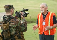 Tech. Sgt. Richard Siers, 37th Communications Squadron, interviews Raul Mancha, chief of the exercise evaluation team, regarding the severe weather military exercise May 21 at Lackland Air Force Base, Texas. Natural Disaster Response Exercises are held periodically to prepare Team Lackland members for a real world situation. (USAF photo by Robbin Cresswell)