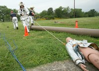 A  Team Lackland fire rescue team extracts a dummy from a ditch May 21 at Lackland Air Force Base, Texas, during a military exercise that lasted about 45 minutes. The exercise was cancelled due to real world severe weather warnings. (USAF photo by Robbin Cresswell)