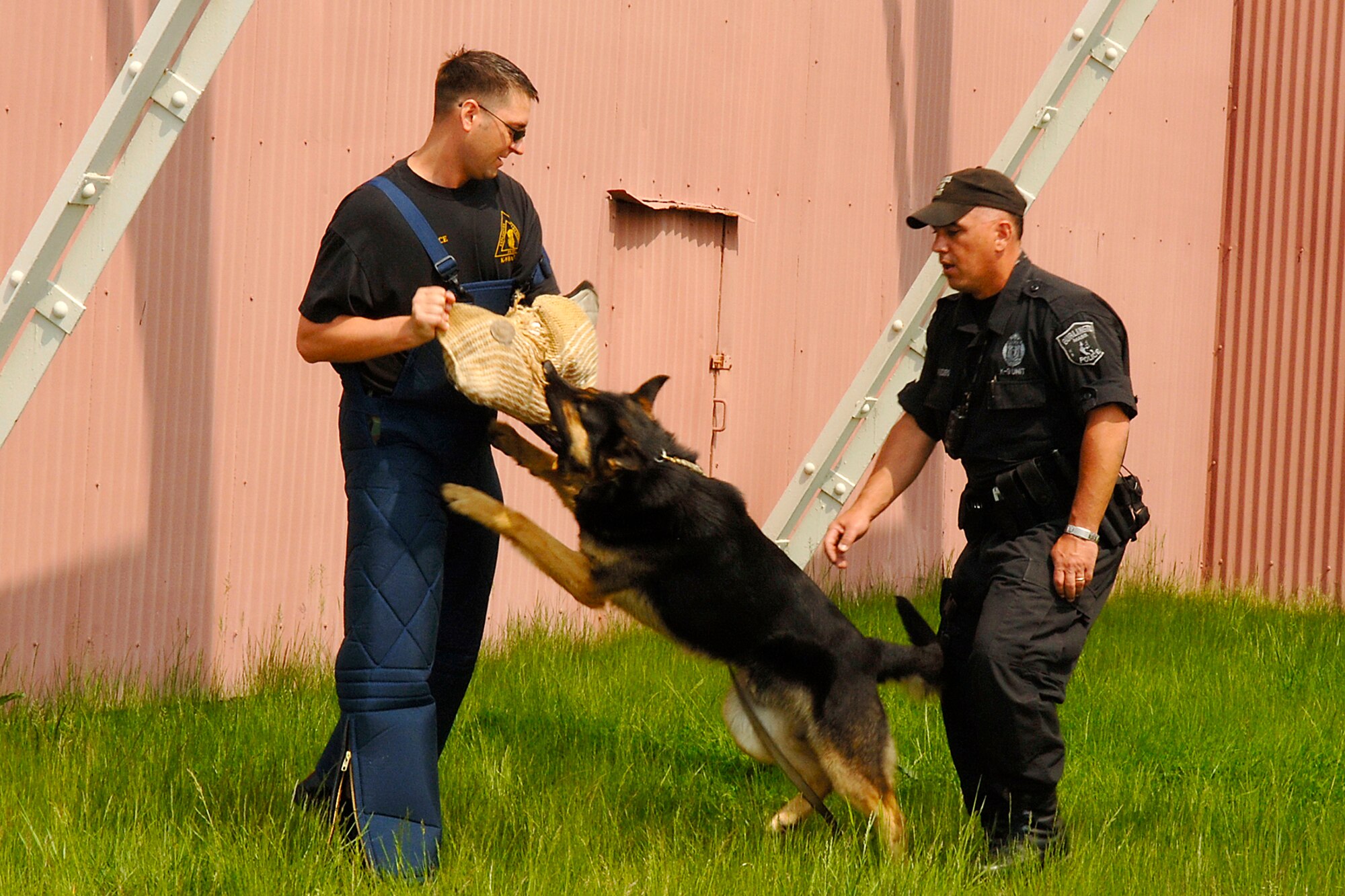 From left, Tech Sgt. Dennis Dolce, 66th Security Forces Squadron, and Officer Joseph Papsedero, Burlington Police Department, with working dog Alex, participate in a K-9 demonstration during Hanscom's Police Week celebration. (US Air Force Photo by Jan Abate)
 
